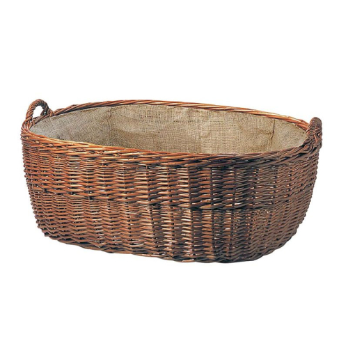 Das Bild zeigt einen ovalen Korb aus Bast mit stabilen Griffen und einem ausgekleideten Stoffinnenfutter. Der Korb ist für den Transport und die Aufbewahrung von Gegenständen wie Wäsche, Holz oder anderen Haushaltsartikeln konzipiert.